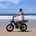 Man riding a fat tyre electric bike on a beach in Australia with dual battery system.